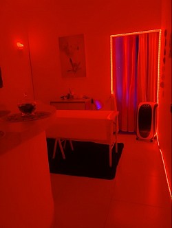 Ambiente preparado para massagens sensuais com luz azul e clima relaxante.